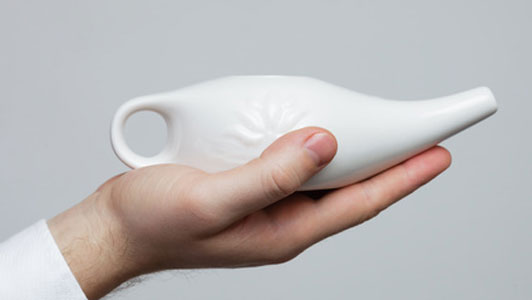 hand holding out neti pot