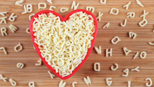 alphabet pasta in heart shaped red bowl