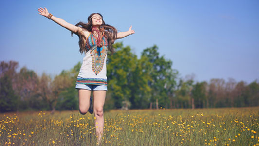 free woman in field jumping