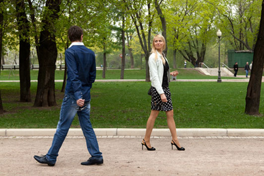 two people crossing paths in park showing mutual interest in each other