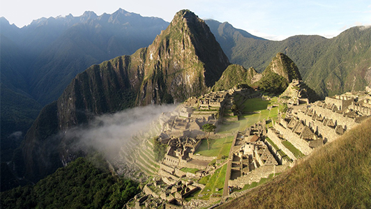 A view of terraced Machu Picchu and a cloud