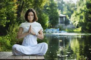 Woman meditating near lake