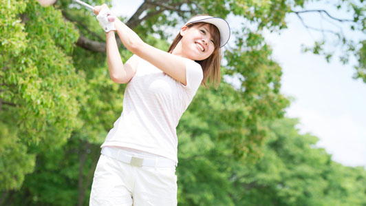 successful young woman swing a golf club