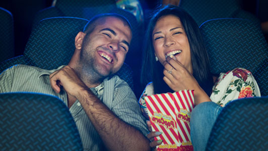 happy couple at movie eating popcorn