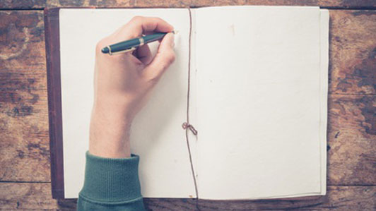 man writing in journal