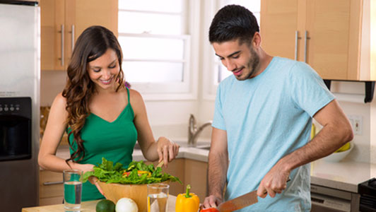 man and woman preparing a meal together