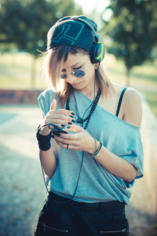 young beautiful model woman listening to music outdoors