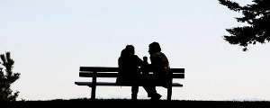 Two people sitting on a bench.