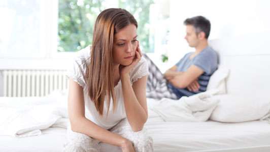 woman thinking at edge of bed