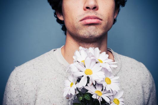 sad guy holding flowers after rejection