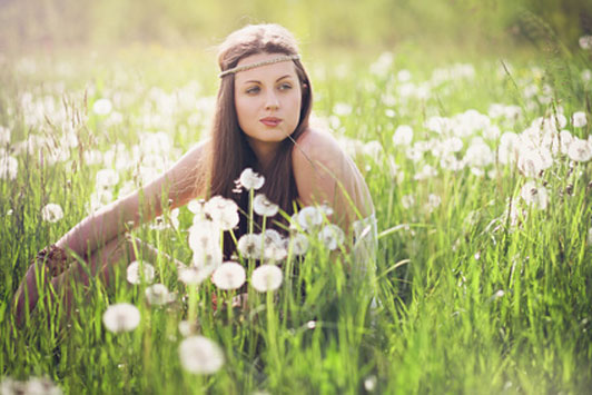 girl in field chewing on grass