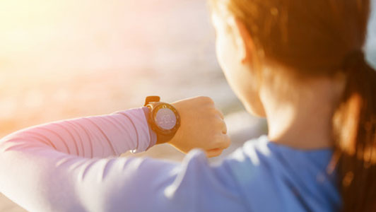 woman looking down at watch checking time