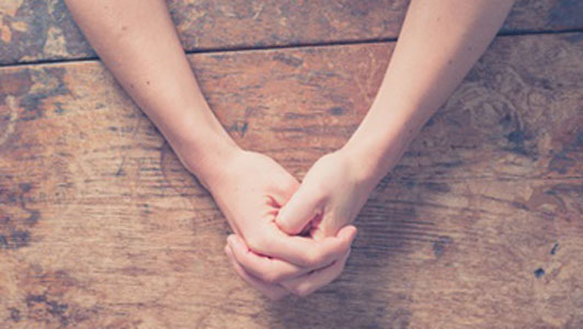 hands praying on table