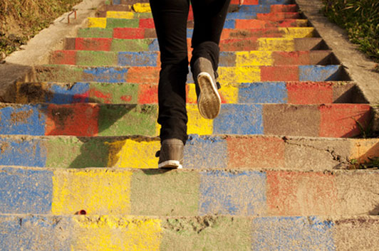 woman climbing colored steps