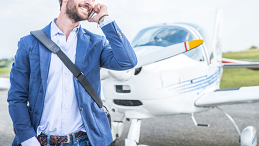 man talking on plane next to private plane