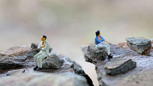 two people in disagreement sitting on rocks