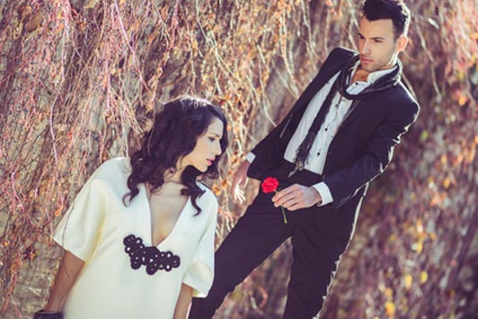 man in suit giving red rose to woman