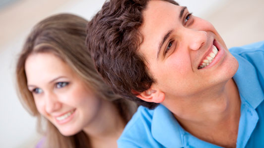 guy smiling with girl behind him