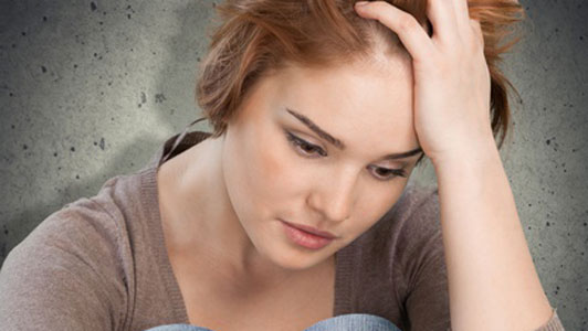 possibly depressed woman with hand on forehead holding up hair thinking