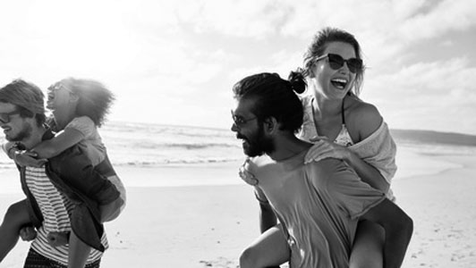 grayscale image of couples having good time at beach