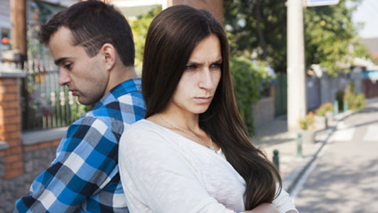 couple back to back in conflict on sidewalk