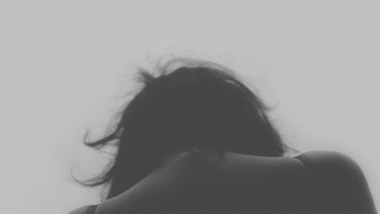 Girl with messy hair bowing her head.