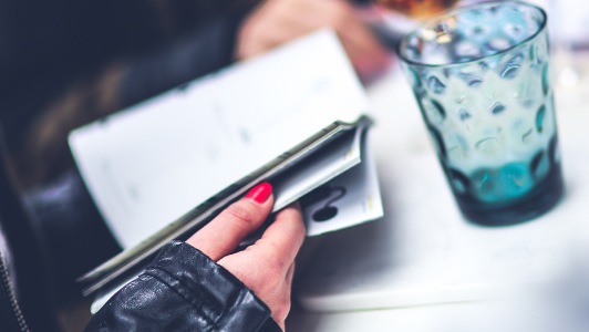 Girl with red nails reading a book.