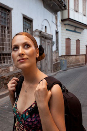 Girl carrying a backpack walking down the street.