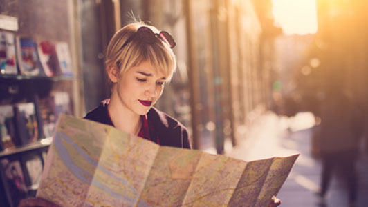 traveling woman looking over map in street