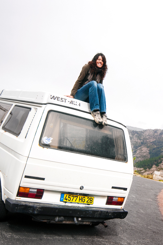 Girl sitting on top of a van.