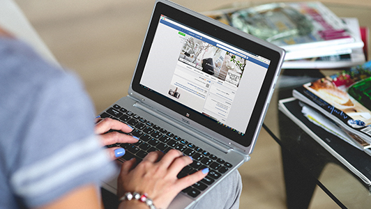 Girl using a netbook to look at someone's facebook profile.