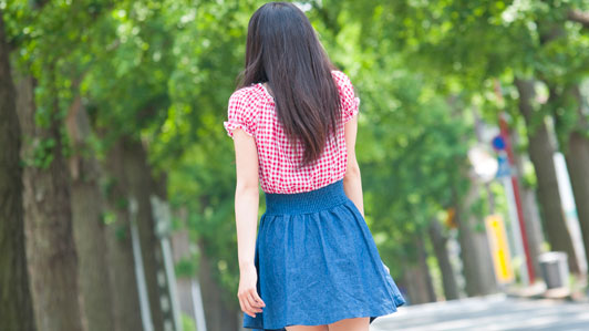 girl in short-sleeve and blue skirt walking outdoors