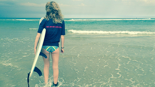 Girl in a tee with a surfing board