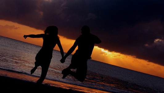 A couple jumping on a beach