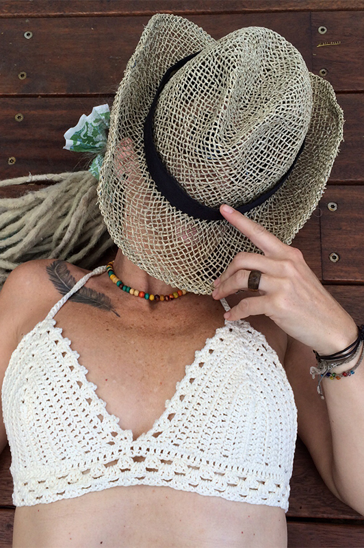 Girl in a white bikini, with a face covered with a hat.