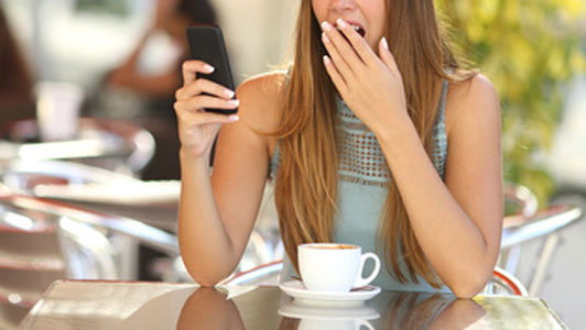 sleepy girl on phone drinking coffee