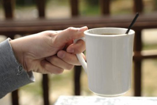 hand of woman holding white mug