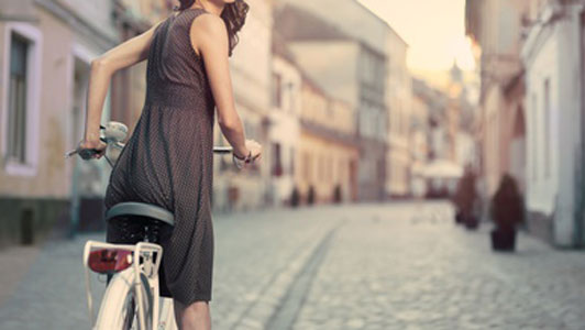 woman in brown dress with polka dots on bicycle