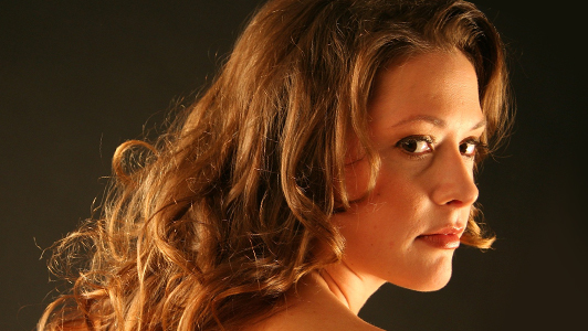 Girl with curly hair looking over her shoulder.