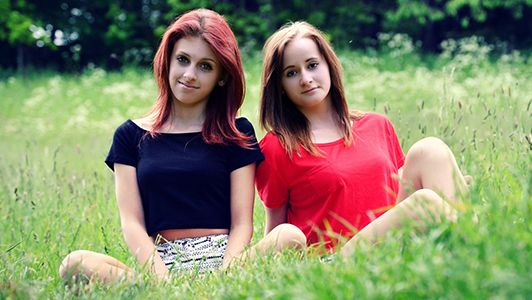 Two girls sitting in the meadow.