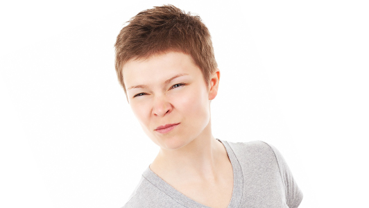 A woman with short hair frowning.