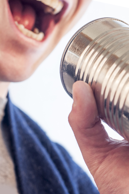 Guy holding a tin can and yelling.