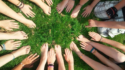 Hands and feet forming a circle on grass