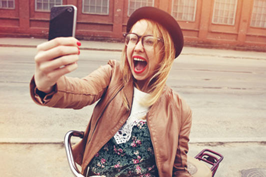 woman on bicycle taking a picture and enjoying herself