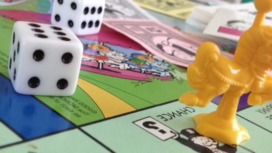 Two die on a Monopoly board.