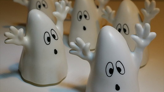 Little toys shaped like ghosts with raised hands.