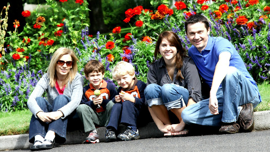 Family with kids sitting on a pavement