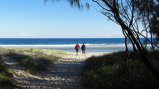 A couple standing on an empty beach.