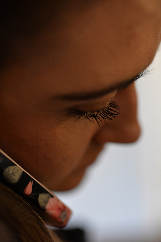 Girl holding a smartphone with flowery case on her ear