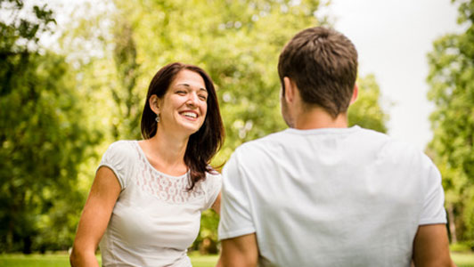 couple in white shirts enjoying talk in park